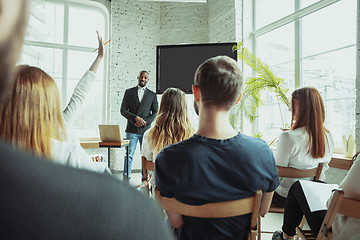 Image showing Male african-american speaker giving presentation in hall at university workshop