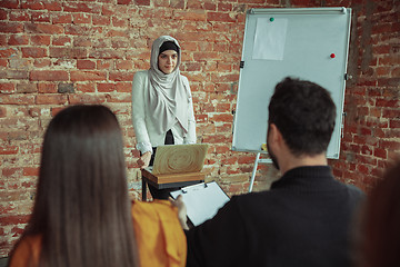 Image showing Female muslim speaker giving presentation in hall at university workshop