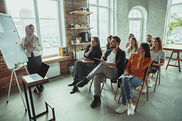 Image showing Female muslim speaker giving presentation in hall at university workshop