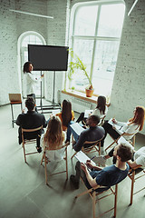 Image showing Female african-american speaker giving presentation in hall at university workshop