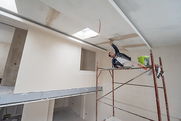 Image showing construction worker plastering on gypsum ceiling