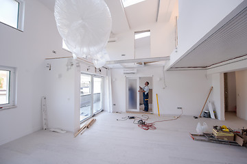 Image showing carpenters installing glass door with a wooden frame