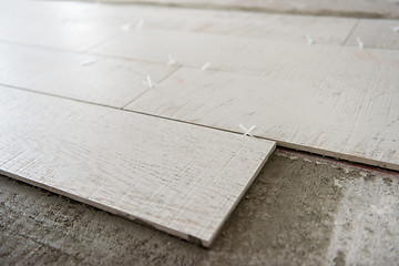 Image showing Ceramic wood effect tiles and tools for tiler on the floor