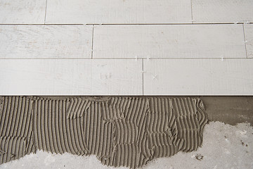 Image showing Ceramic wood effect tiles and tools for tiler on the floor