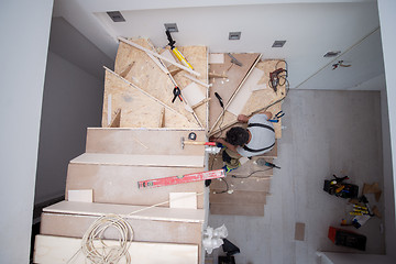 Image showing carpenter installing wooden stairs