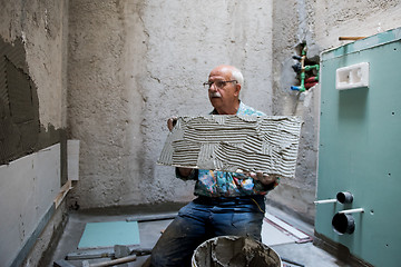 Image showing worker installing big ceramic tiles