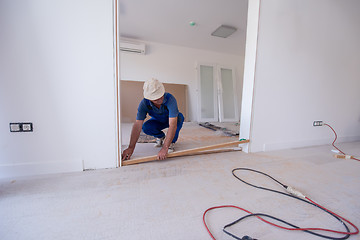 Image showing carpenters installing glass door with a wooden frame