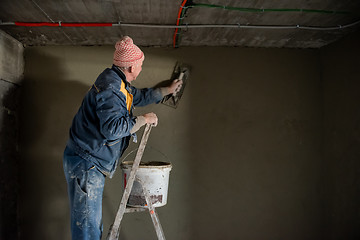 Image showing Worker plastering the wall by concrete