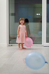 Image showing cute little girl playing with balloons