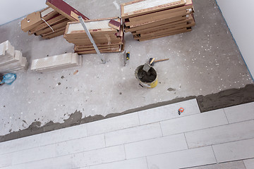 Image showing Ceramic wood effect tiles and tools for tiler on the floor