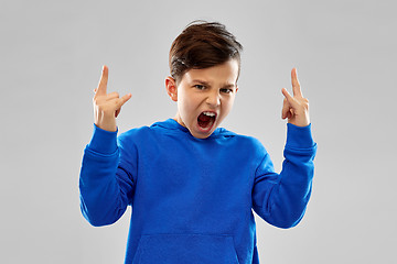 Image showing angry boy in blue hoodie showing rock gesture