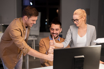 Image showing business team making thumbs up gesture at office