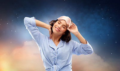 Image showing happy young woman in pajama and eye sleeping mask