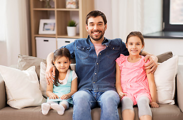 Image showing happy father with daughters on sofa at home