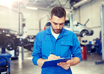 Image showing auto mechanic man with clipboard at car workshop