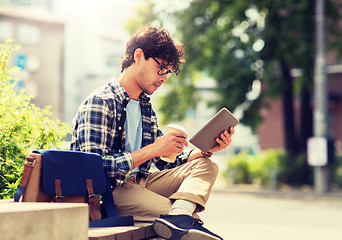 Image showing man with tablet pc sitting on city street bench