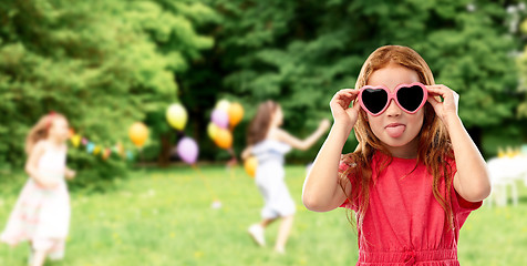 Image showing naughty red haired girl in heart shaped sunglasses