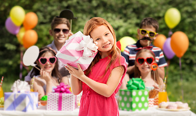 Image showing lovely red haired girl with birthday gift at party