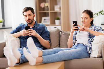 Image showing couple with smartphones at home