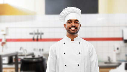 Image showing happy indian chef in toque at restaurant kitchen