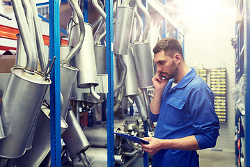 Image showing auto mechanic calling on phone at car shop