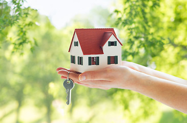 Image showing close up of hands holding house model and keys