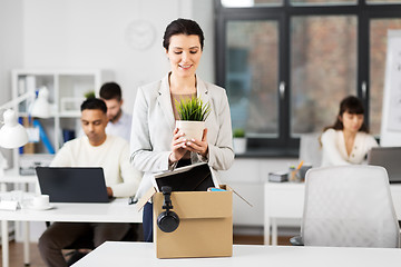 Image showing happy businesswoman with personal stuff at office