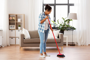 Image showing woman with sweeping broom brush cleaning floor