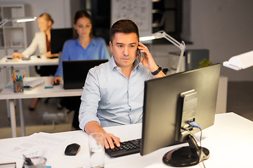 Image showing man calling on smartphone at night office