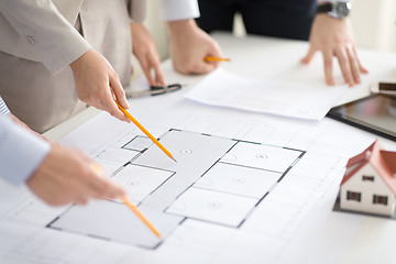 Image showing close up of architects with blueprint at office