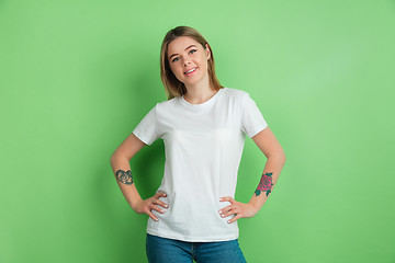 Image showing Caucasian young woman\'s portrait on green studio background
