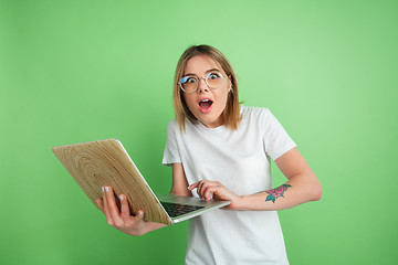 Image showing Caucasian young woman\'s portrait on green studio background