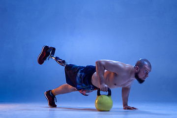 Image showing Athlete disabled amputee isolated on blue studio background