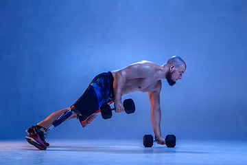 Image showing Athlete disabled amputee isolated on blue studio background