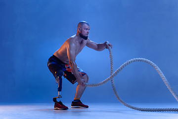 Image showing Athlete disabled amputee isolated on blue studio background