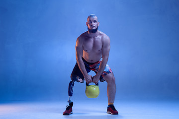 Image showing Athlete disabled amputee isolated on blue studio background