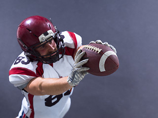 Image showing american football player showing football to camera