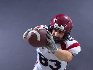 Image showing american football player showing football to camera