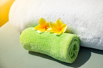 Image showing Pretty yellow plumeria flowers on towels