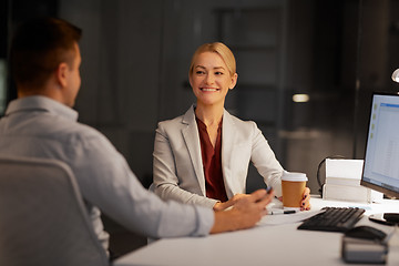 Image showing business people drinking coffee at night office