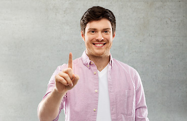 Image showing man showing one finger over gray concrete wall