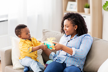 Image showing happy mother giving present to her baby at home