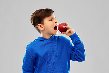 Image showing angry boy in blue hoodie with red apple