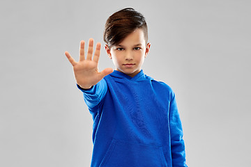 Image showing boy in blue hoodie making stopping gesture