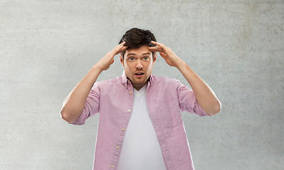 Image showing man touching his head over grey concrete wall