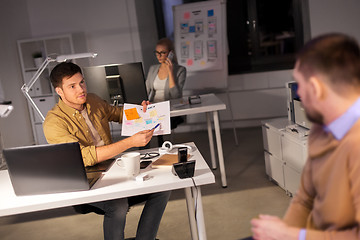 Image showing business team with papers working late at office