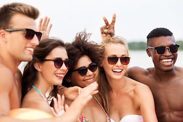 Image showing happy friends in sunglasses on summer beach