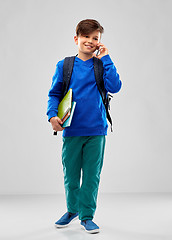 Image showing student boy with school bag calling on smartphone