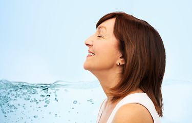 Image showing profile of smiling senior woman over blue water