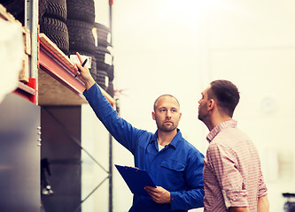 Image showing auto mechanic with clipboard and man at car shop